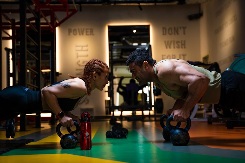 a-man-and-a-woman-doing-push-ups-with-kettles-mtcpxu8b31i